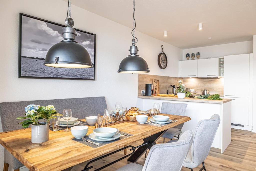 a kitchen and dining room with a wooden table and chairs at Schlei-Koje 1 in Schleswig