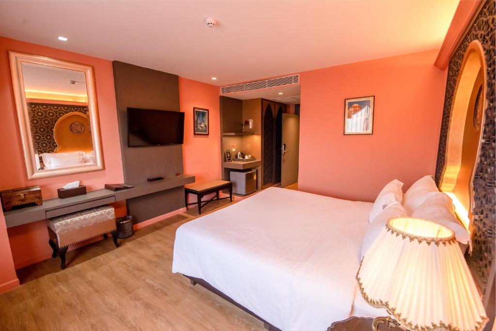 a bedroom with a white bed and orange walls at Amman Unique Hotel in Udon Thani