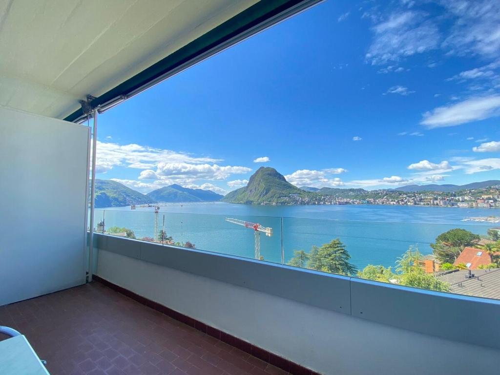 a room with a large window with a view of the water at Appartamento VistAcqua in Lugano