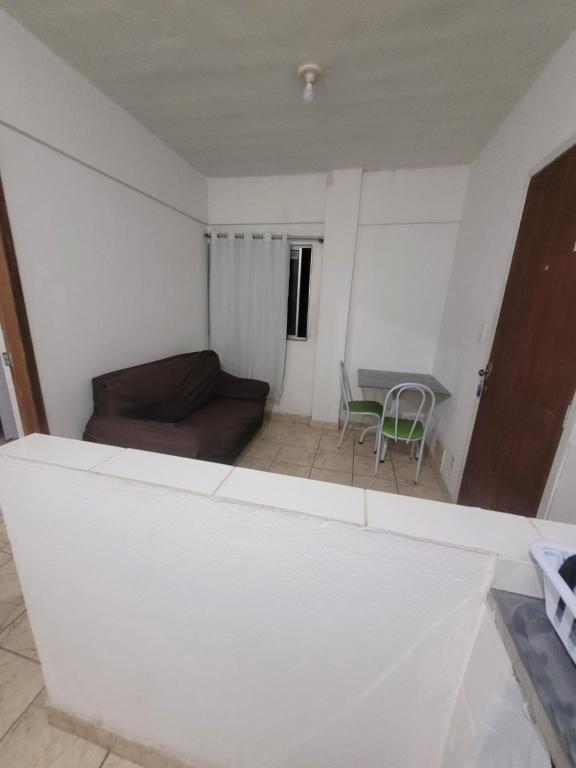a living room with a couch and a table at Espaçosa kitnet em itapua 10 min da praia. in Vila Velha