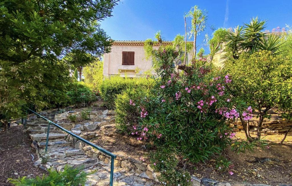 a garden with pink flowers and trees and a building at Maison centre ville vue mer in Le Lavandou