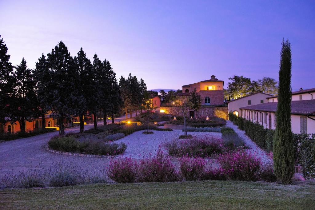 un jardín con flores púrpuras frente a un edificio en Luxury Apartment in Siena Resort, en Trequanda