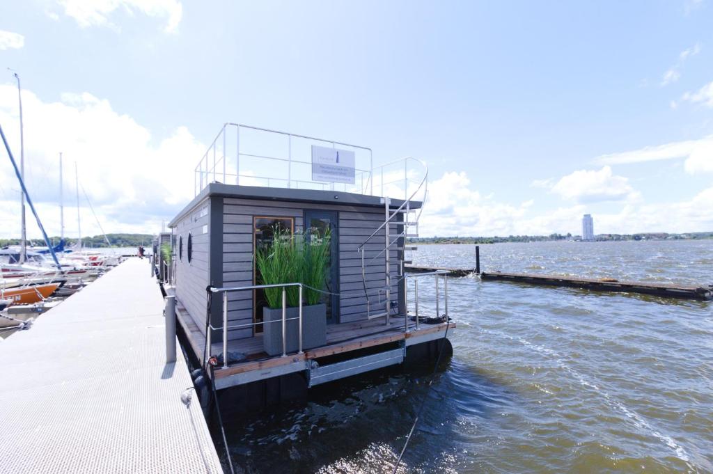 a small house on a boat in the water at Hausboot Fjord Serina mit Biosauna in Schleswig in Schleswig