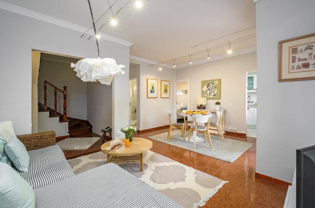 een woonkamer met een bank en een tafel bij Sant'Ana Cottage in Cascais