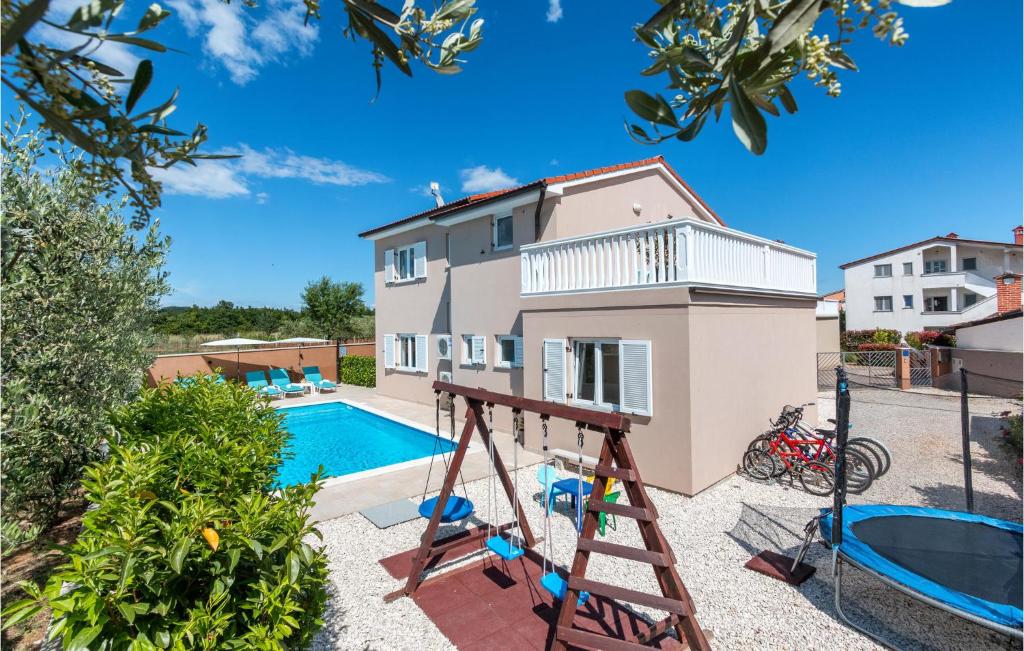 a villa with a swimming pool and a house at 3 Bedroom Cozy Home In Loborika in Loborika