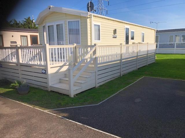 a house with a white fence next to a yard at Birchington Vale entire holiday home in Westgate on Sea