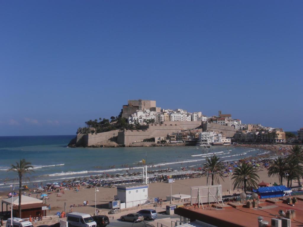 a view of a beach with a castle in the background at Apartamentos Peñíscola Playa in Peniscola