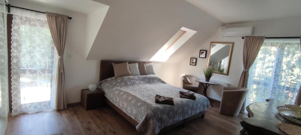 a bedroom with a bed and a large window at Natura Panzió Szilvásvárad in Szilvásvárad