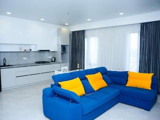 a blue couch with yellow pillows in a kitchen at D-S Apartament in Kutaisi in Kutaisi