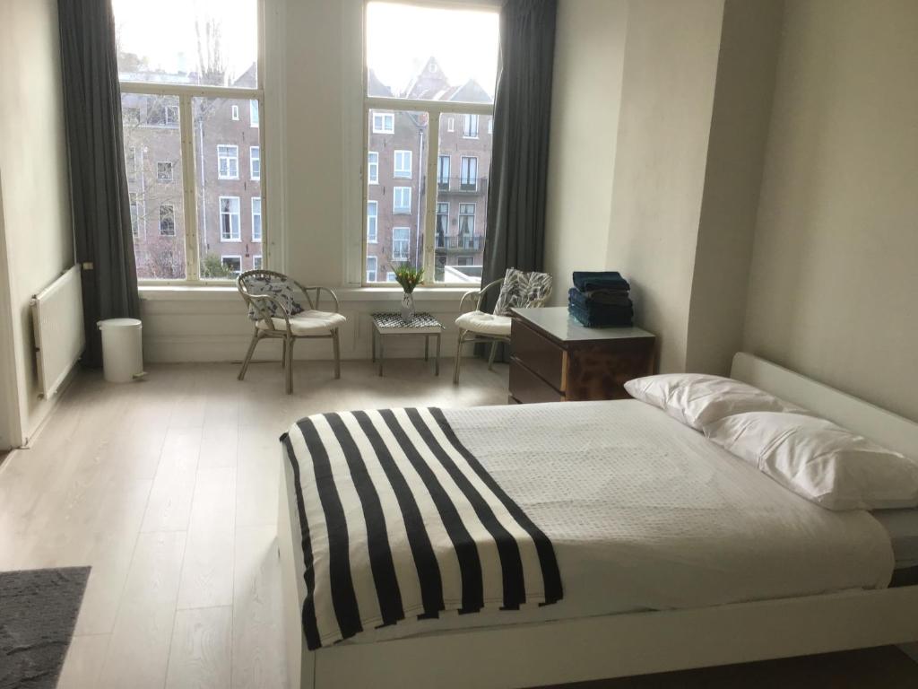 a bedroom with a bed and a large window at Frank’s and Chong’s excellent location in Amsterdam