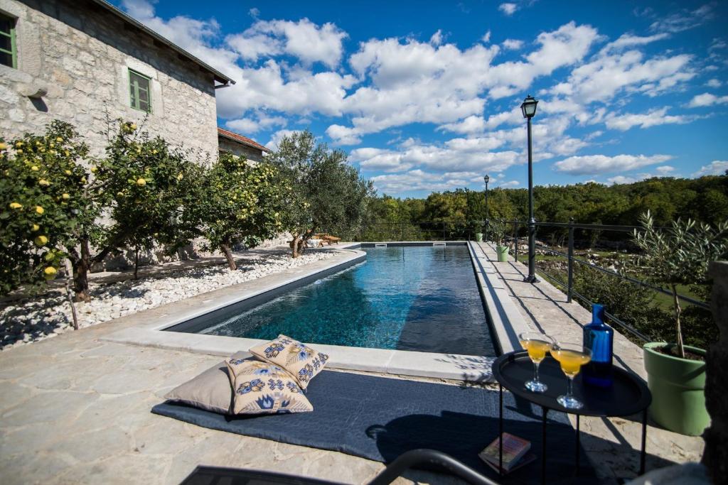 a swimming pool in a backyard with a table and chairs at Villa Ana in Ivanica