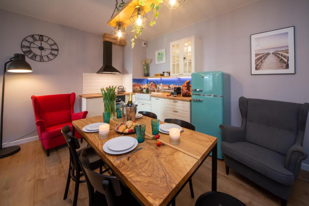 a kitchen and dining room with a table and a refrigerator at Maya's Flats & Resorts 62 - 3 rooms apartment BASTION WALOWA Gdańsk in Gdańsk
