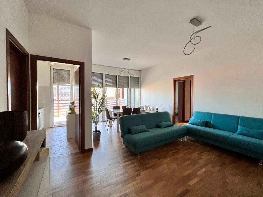 APPARTAMENTO DE LUXE GIADA في بولونيا: غرفة معيشة مع أرائك زرقاء وغرفة طعام