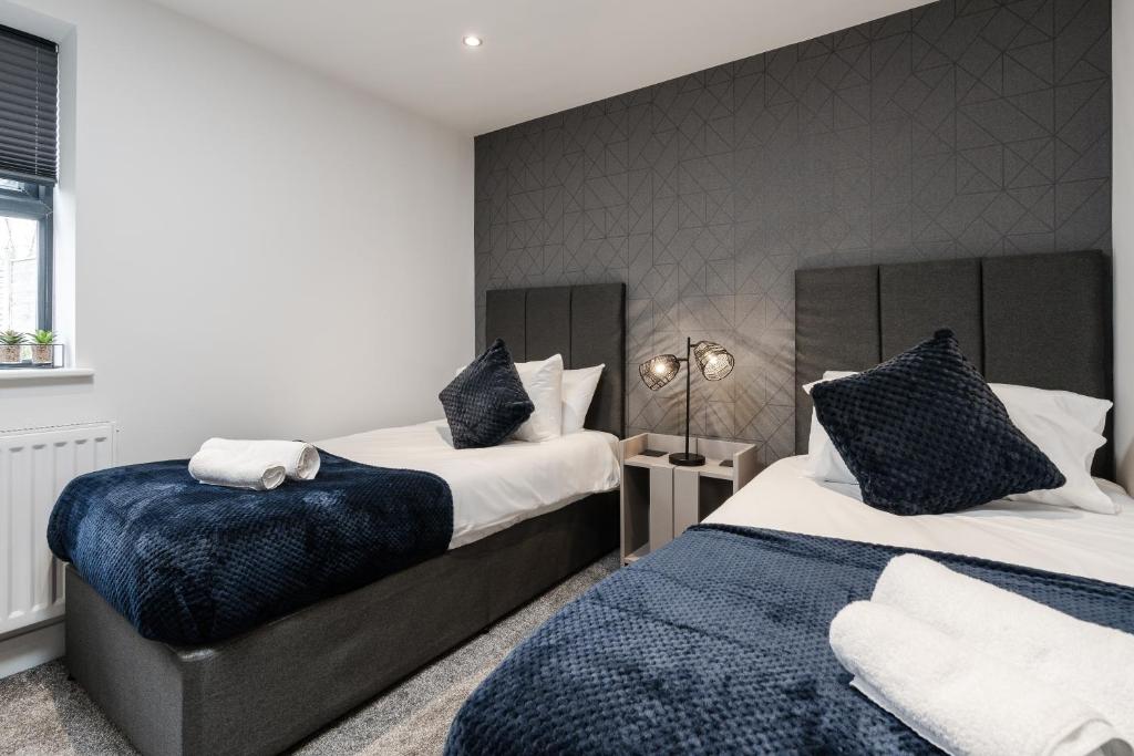 1 dormitorio con 2 camas con sábanas azules y blancas en Victoria Home - 2 Bedroom Wi-Fi Parking Workers en Hyde