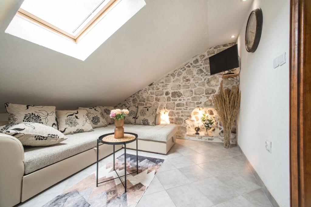- un salon avec un canapé et un mur en pierre dans l'établissement Little Bay Apartments, à Kotor