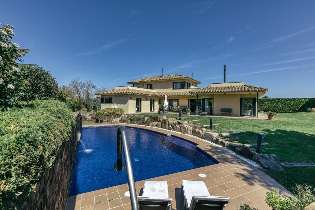 a swimming pool in front of a house at Luxury Golf Villa Torremirona in Navata