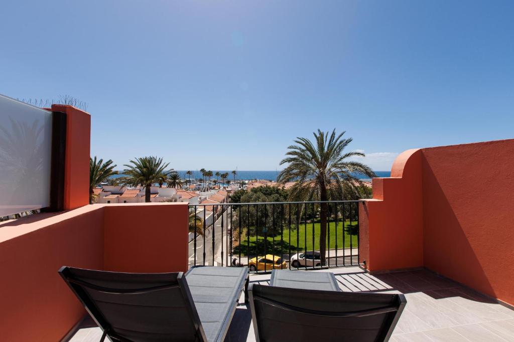 a balcony with chairs and a view of the beach at Chalet adosado en Pasito PTOM23 in Pasito Blanco