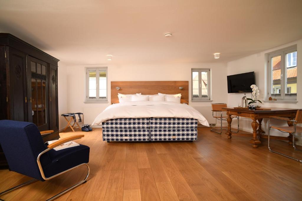 a bedroom with a bed and a desk and a television at chez Douverne Hotel mit Hästens Betten in Sommerach