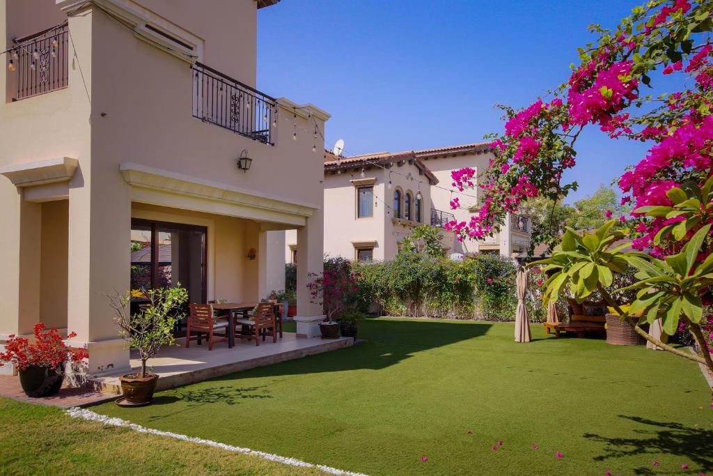 une cour d'une maison avec une pelouse verdoyante dans l'établissement Spacious,amazing villa with a beautiful blooming garden!, à Dubaï