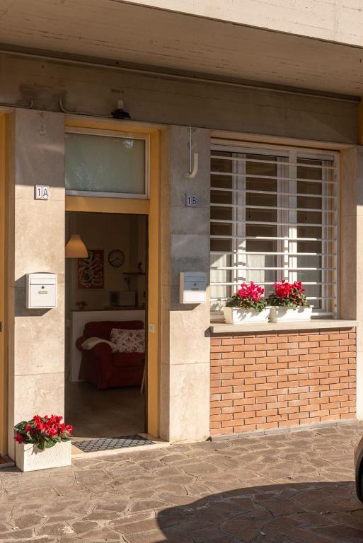 budynek z dwoma oknami z kwiatami w obiekcie La dimora di Amélie w mieście San Lazzaro di Savena