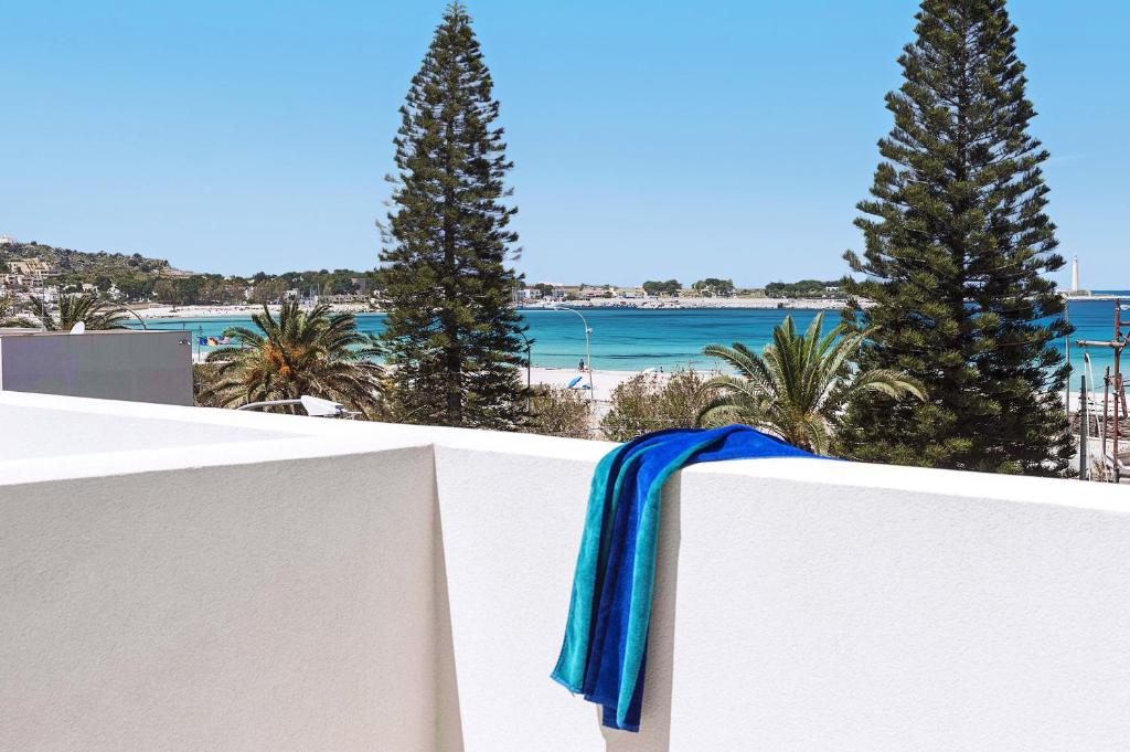 a blue scarf on a white fence overlooking the beach at Lisca Bianca in San Vito lo Capo