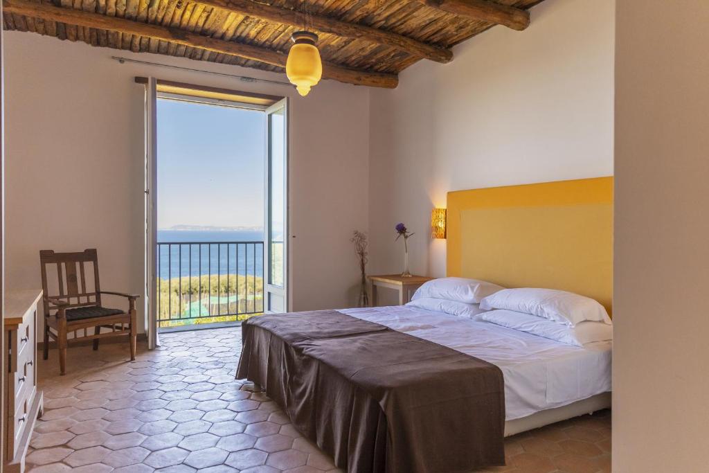 um quarto com uma cama grande e uma janela grande em Villa Puolo - With Private Sea Access em Sorrento