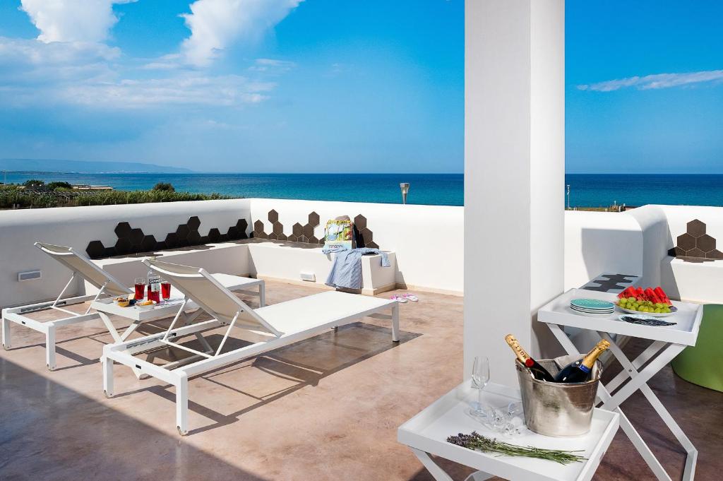 un patio avec une table et des chaises et l'océan dans l'établissement San Lorenzo - Fico d'India, à Syracuse