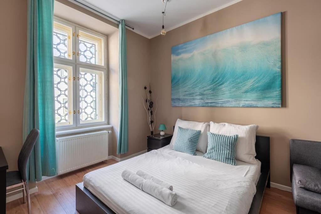 a bedroom with a bed and a large painting on the wall at Vals Garden Apartment in Prague