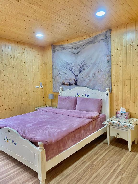 sypialnia z łóżkiem z obrazem na ścianie w obiekcie Temu 鐵木蘭農場 w mieście Gauyi