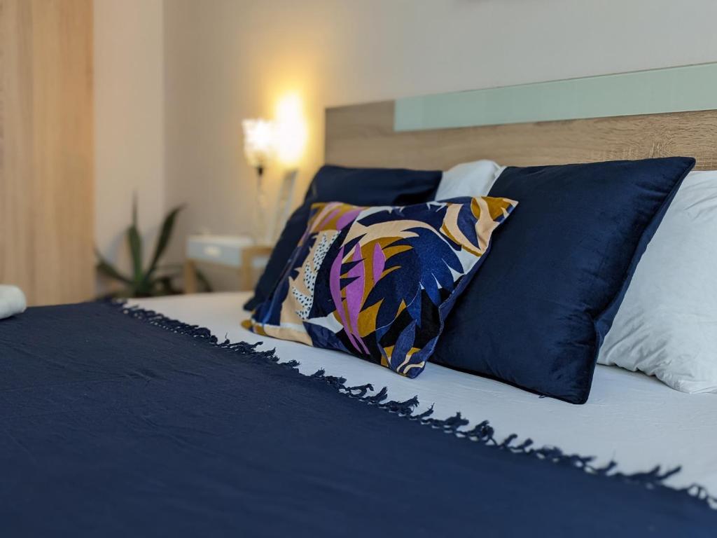 uma cama com lençóis e almofadas azuis e brancos em Welcome Stara Zagora Apartment 4 Guests Pet Friendly em Stara Zagora