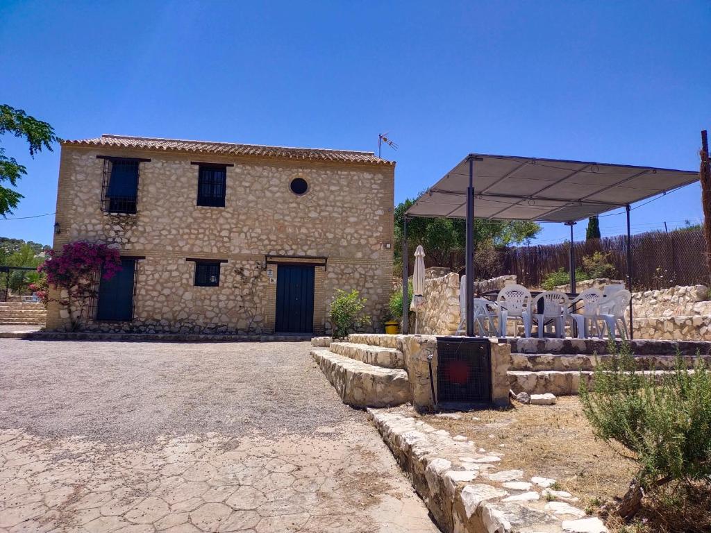 un grande edificio in pietra con una tenda di fronte ad esso di Casas Rurales Las Viñas a Osuna