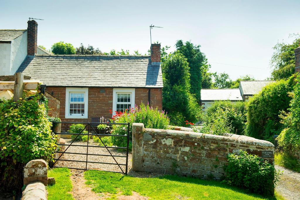 a brick house with a gate in a garden at OLD CHAPEL Hayton Cumbria CA89HR in Hayton