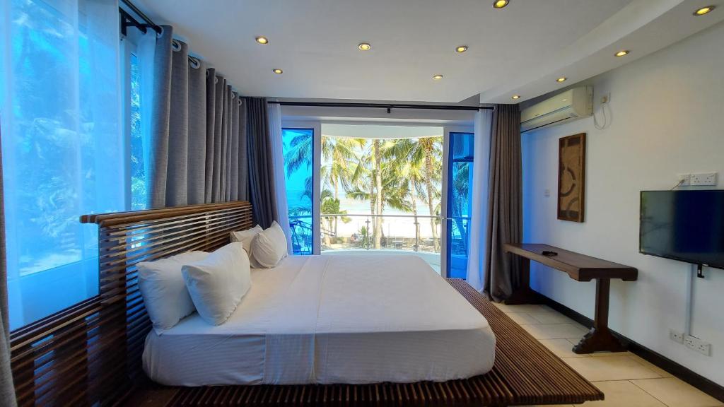 a bedroom with a bed and a large window at c3 Cowrie Shell Residences in Mombasa