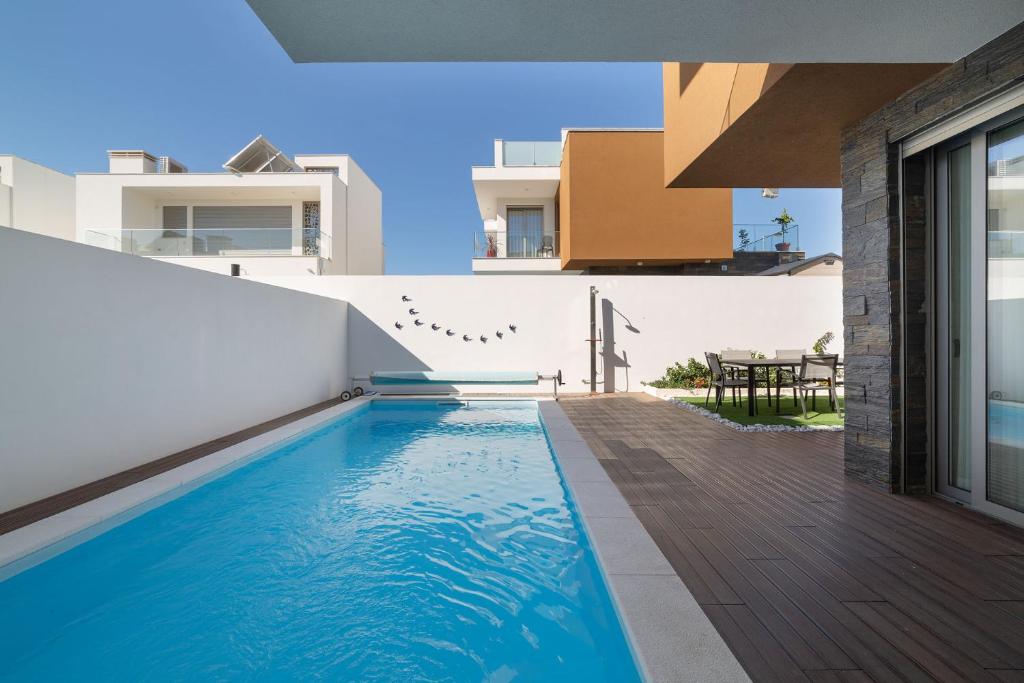 a swimming pool in the backyard of a house at Villa Atlântico - By SCH in Salir do Porto