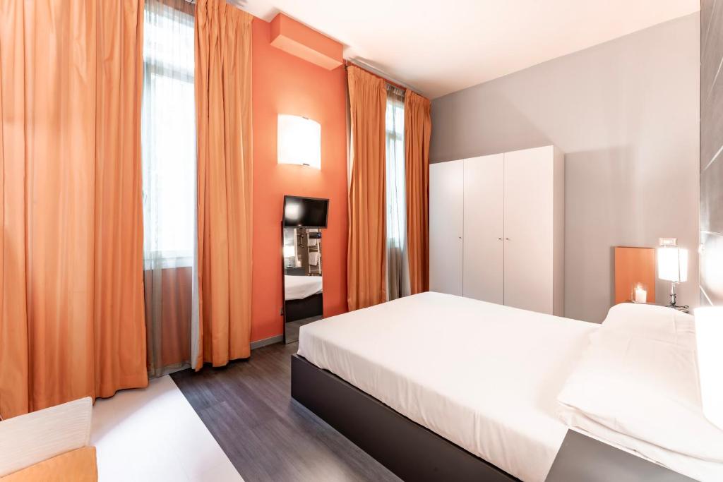 a bedroom with a white bed and orange curtains at Residenza Manin Apartments in Venice