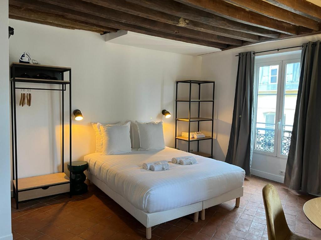 a bedroom with a white bed and a window at Conde Chic Studio in Paris