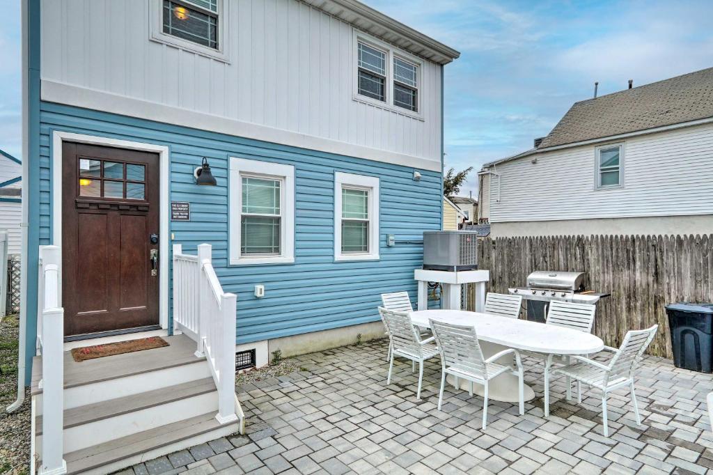a blue and white house with a table and chairs at Modern Townhome Walk to Beach, Bars and Eats! in Seaside Heights