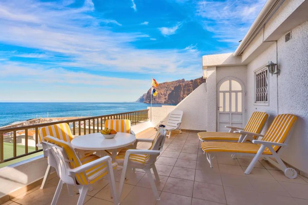 a balcony with a table and chairs and the ocean at Los Gigantes Sea View in Santiago del Teide