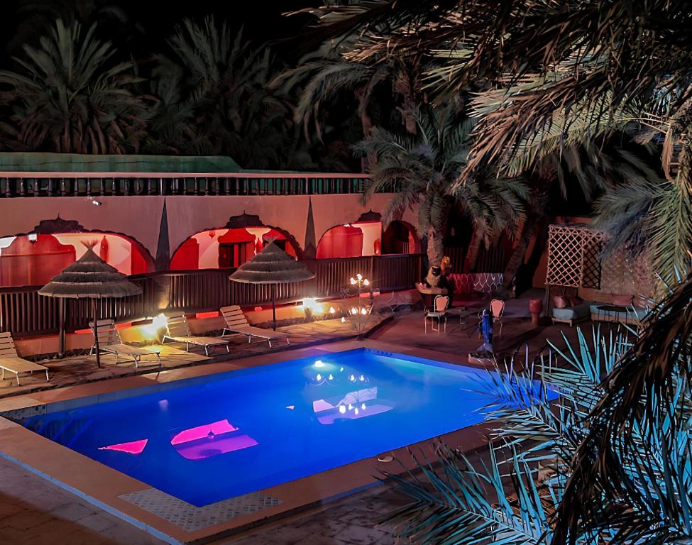 a swimming pool in a resort at night at Riad Ambelar in Erfoud