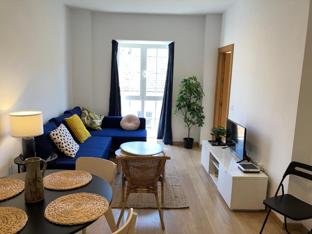 sala de estar con sofá azul y mesa en Malaga Victoria, en Málaga