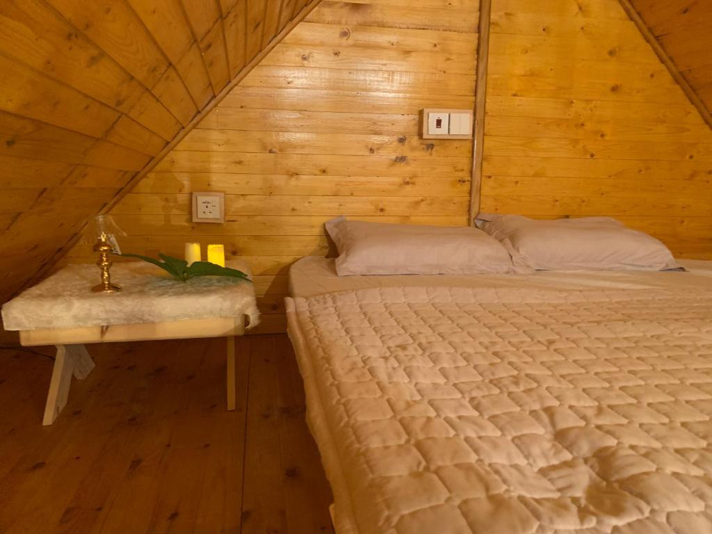 a bedroom with two beds in a wooden cabin at شالية ديما الريفي ٢ in As Sayl aş Şaghīr
