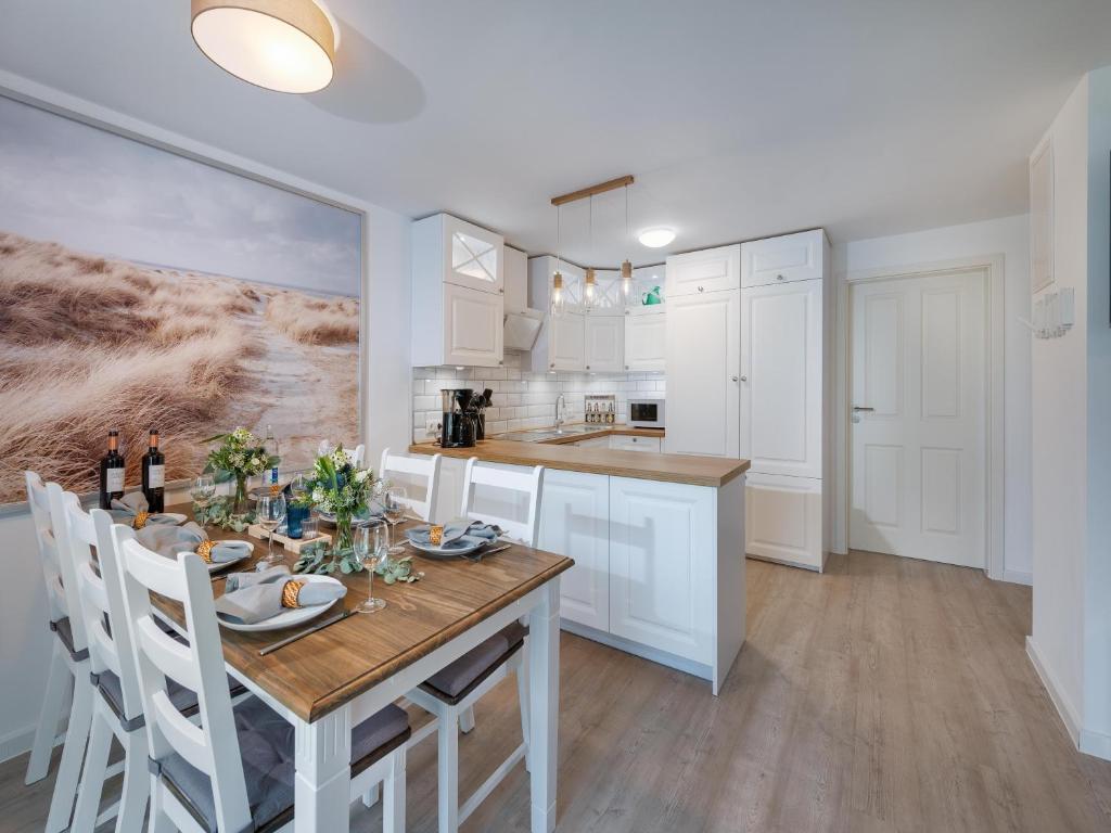 a kitchen with a wooden table and white cabinets at Beliebte Ferienwohnungen in Flensburg in Flensburg