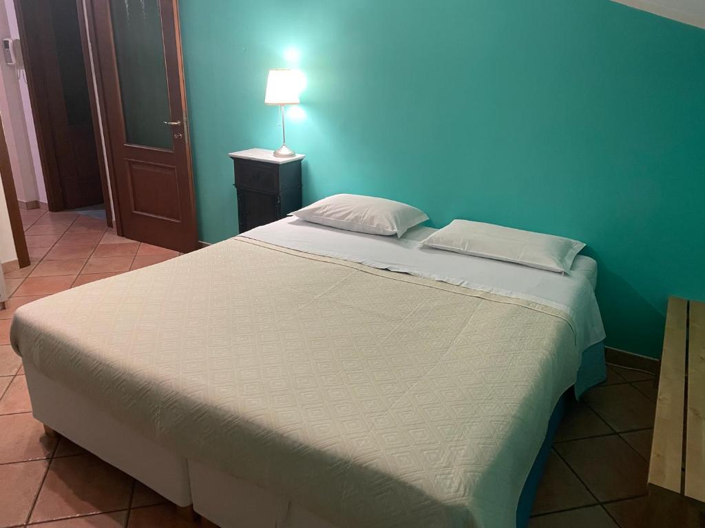 a large bed in a room with a blue wall at Soggiorno con splendida vista in Monforte dʼAlba