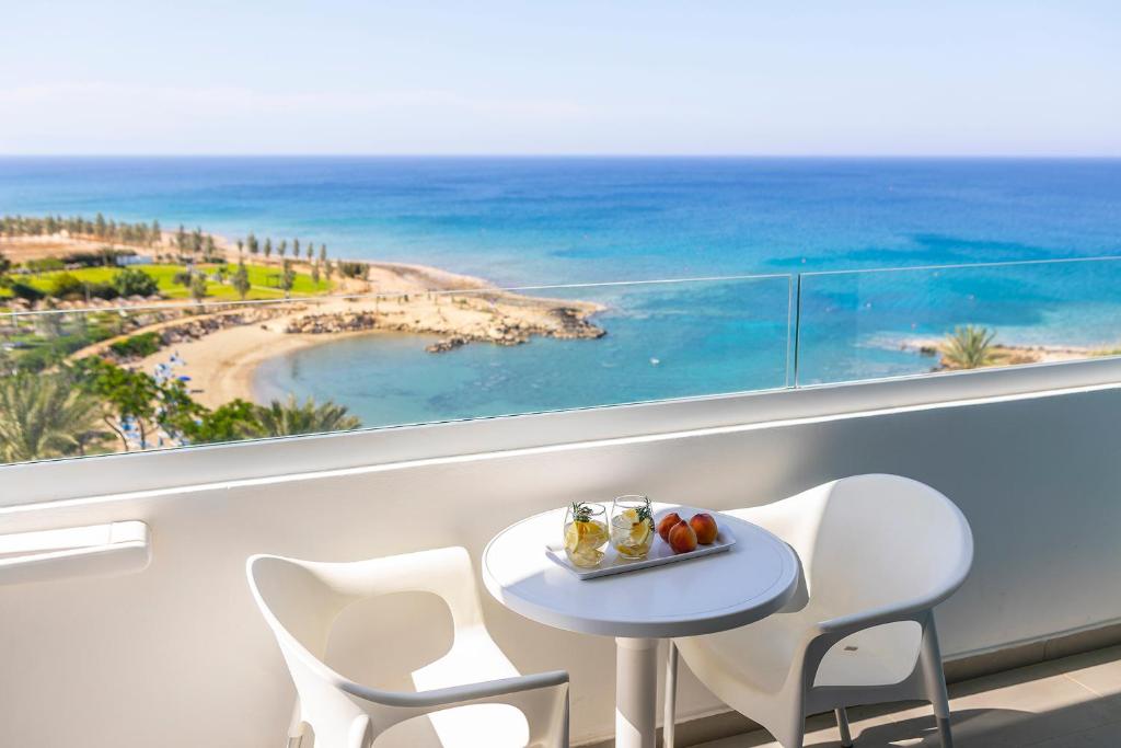 un tavolo e sedie su un balcone con vista sulla spiaggia di Crystal Springs Beach Hotel a Protaras