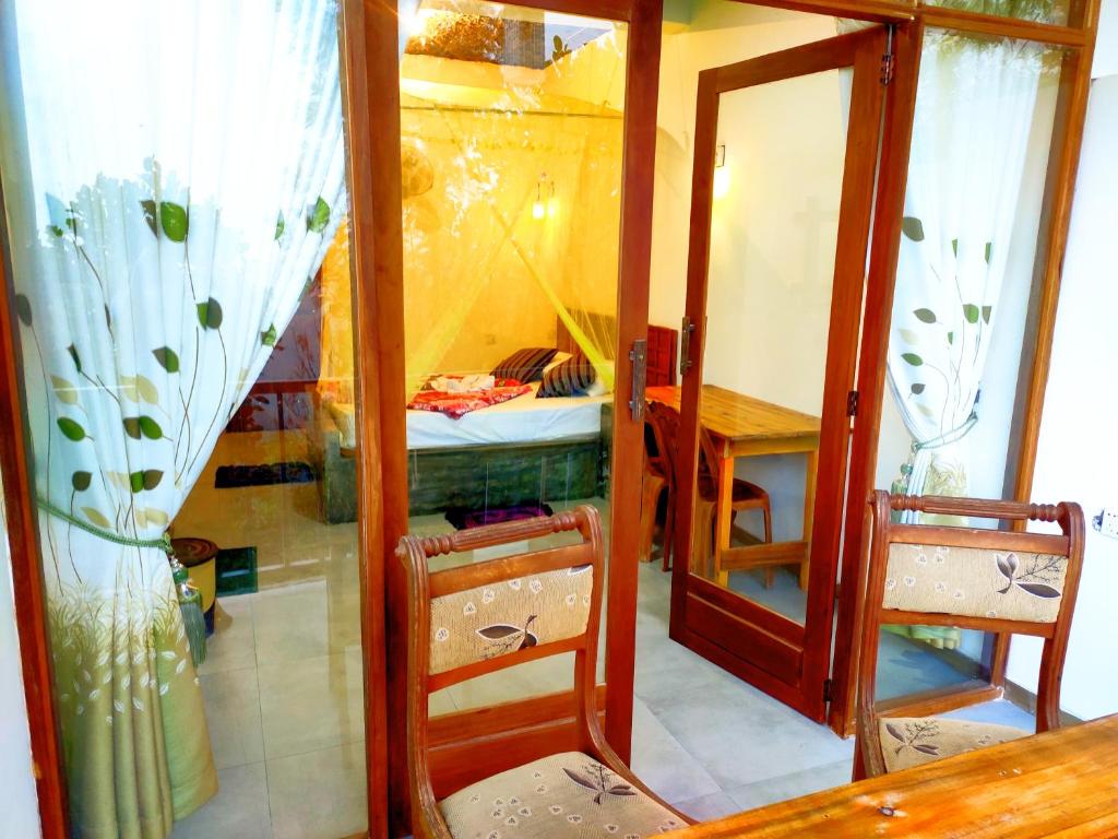 a room with a table and two chairs and a mirror at Rock Paradise Homestay in Ella