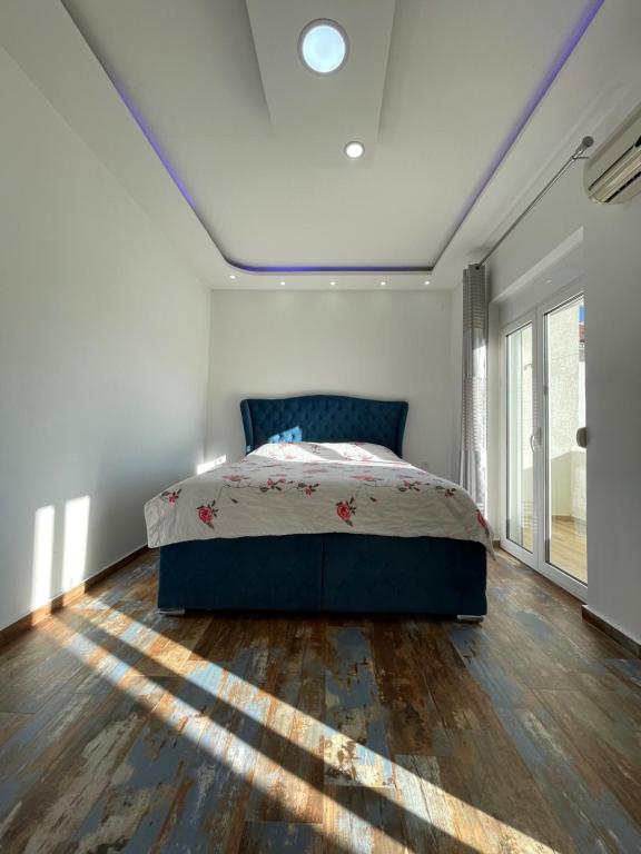 a bedroom with a bed and a large window at Apartmani centar ulcinj in Ulcinj