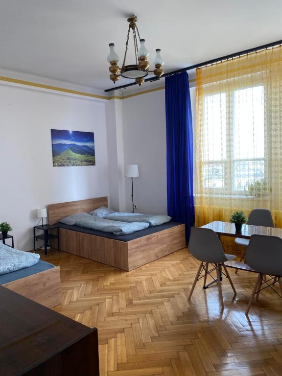 1 dormitorio con 1 cama, mesa y sillas en Vintage Rooms in Old Town en Cracovia