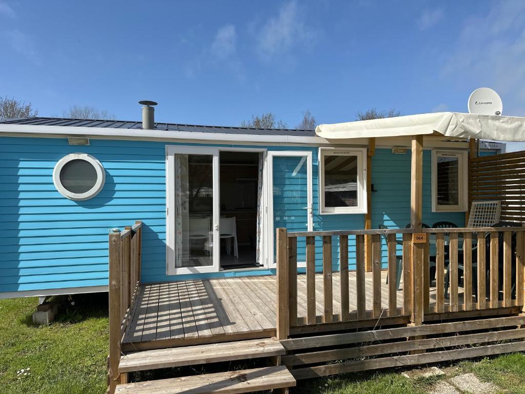 een blauw tiny house met een houten terras bij mobil home 6 places tout confort in Saint-Georges-de-Didonne