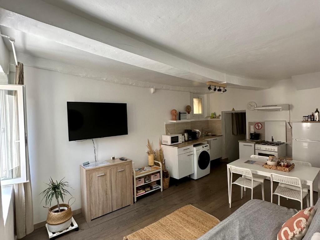 a living room with a tv and a kitchen at Appartement cocooning in Saorge