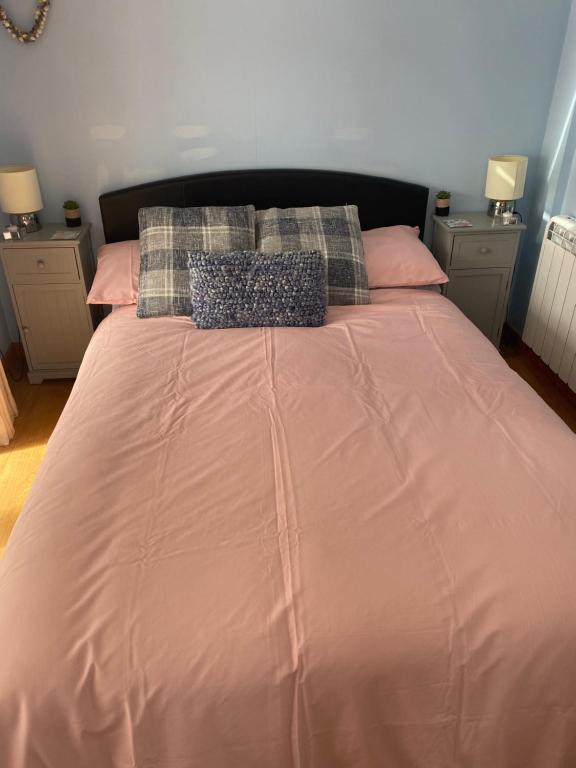 a large pink bed with two pillows on it at The little crab hut in Sheringham